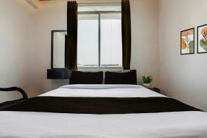 a bedroom with a large bed with a window at HOTEL O MJ INN in Darbhanga