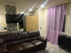 a living room with a leather couch and a television at Village house in Telavi +6 photos