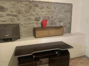 a stone wall with a counter and a tv on a shelf at Village house in Telavi