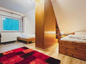 a bedroom with two beds and a red rug at Zaunkönigs Nest in Böhl