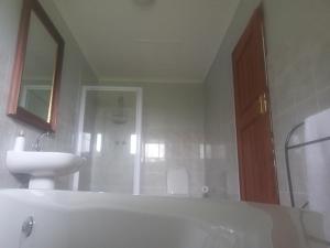 a bathroom with a white tub and a sink at Eagles Lodge One in Vosburg