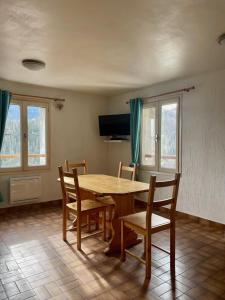 a dining room with a wooden table and chairs at Les crocus in Roubion