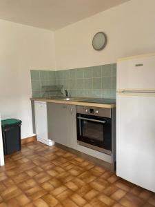 a kitchen with a stove and a refrigerator in it at Les crocus in Roubion