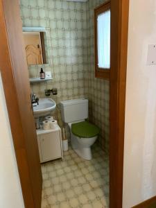 a bathroom with a toilet and a sink at Cottage Grundschera Engadin in Brail