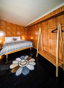 a bedroom with a bed with a flower rug at Garden House Balangan in Uluwatu