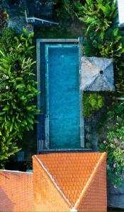 an orange bench in front of a blue door at Garden House Balangan in Uluwatu