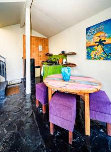 a wooden table and purple chairs in a room at Garden House Balangan in Uluwatu