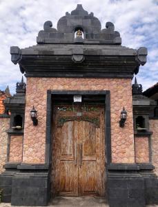 a large wooden door on a brick building at Garden House Balangan in Uluwatu +3 photos