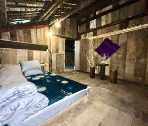a bedroom with a bed in a room with wooden walls at Hoàng Thông Homestay in Mia Si
