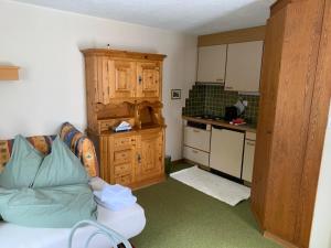 a small kitchen with a couch in a room at Cottage Grundschera Engadin in Brail