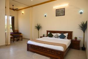 a bedroom with a large bed and a piano at Baghin Resort in Khilchipur