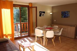 a living room with a table and chairs and a kitchen at Les biches in Roubion