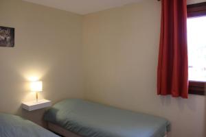 a bedroom with a bed and a window with a lamp at Les biches in Roubion