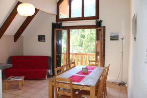 a living room with a table and a red couch at Les chamois in Roubion