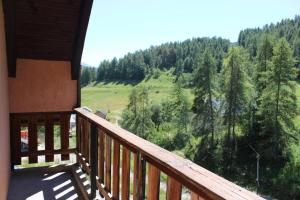 a balcony of a cabin with a view of a forest at Les chamois in Roubion +7 photos