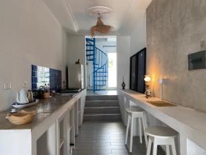 a kitchen with a long counter with stools in it at Birdhouse Sidi Bou Said in Dar Mimoun Bey