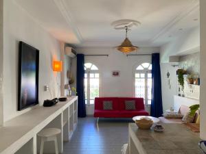 a living room with a red couch and a red chair at Birdhouse Sidi Bou Said in Dar Mimoun Bey