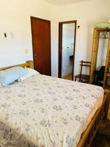 a bedroom with a bed with a floral bedspread at TAIBA - ONDAS DO MAR RESIDENCE Ap 212 - Rezende Temporada in São Gonçalo do Amarante +53 photos