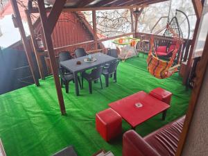 a patio with a table and chairs and a swing at Casa ROOL in Turda