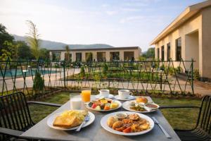 a table with plates of food and drinks on it at Baghin Resort in Khilchipur