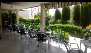 a row of tables and chairs on a patio at Pensión El Chalet in Torrejoncillo del Rey