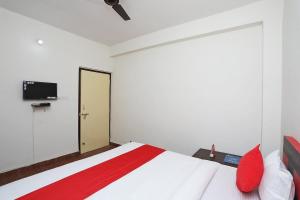 a bedroom with a white bed and a tv at Hotel Sintle Palace in Bhubaneshwar