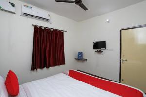 a bedroom with a red and white bed and a window at Hotel Sintle Palace in Bhubaneshwar