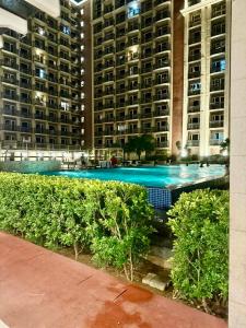 a large swimming pool in front of a large building at Staycation near MOA at Monarch in Manila