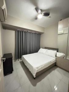 a bedroom with a bed and a ceiling fan at Staycation near MOA at Monarch in Manila +10 photos