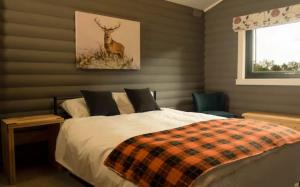 a bedroom with a bed and a deer painting on the wall at Cateran Rest in Kirkmichael