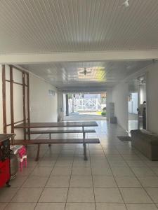 a empty room with a bench and a table at Casa de lazer e tranquilidade in Tramandaí +1 photo