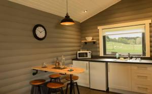 a kitchen with a table and a clock on the wall at Cateran Rest in Kirkmichael