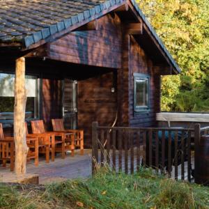 a log cabin with chairs on a porch at Cateran Rest in Kirkmichael