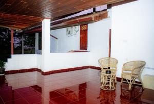 two chairs sitting on the porch of a house at Casa Hikka Villa in Sinigama