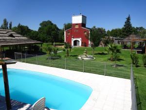 a pool in front of a red barn with a house at Apart Hotel La Bodega in San Rafael +13 photos