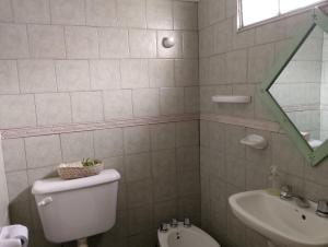 a bathroom with a toilet and a sink at Aldea Grampas in Embalse