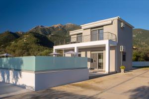 a house with mountains in the background at Valora Villa in Nydri