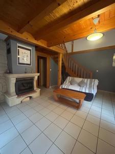 a living room with a fireplace and a staircase at Gîtes de Charme en Isère in Sonnay