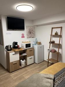 a room with a kitchen with a microwave and a refrigerator at Maison les étoiles in Hésingue