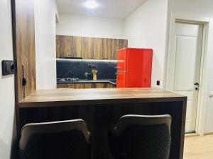 a kitchen with a counter and a red refrigerator at Cozy apartment for a comfortable vacation in Itʼkhvisi