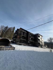 a building with snow in front of a building at Cozy apartment for a comfortable vacation in Itʼkhvisi