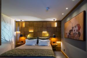 a bedroom with a large bed with two pillows at Wood Hotel in Gramado
