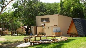 a building with a fire pit in a yard at Glamping in Lavrinhas