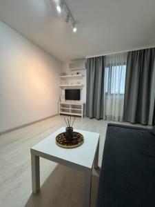 a living room with a white table and a tv at Apartment Pitesti in Piteşti