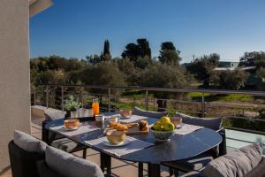 a table with a bowl of fruit on a balcony at Valora Villa in Nydri