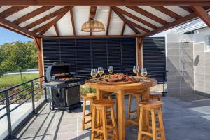a patio with a table with wine glasses and a stove at Villa 4 étoiles Le Roc de Malendure in Bouillante +31 photos