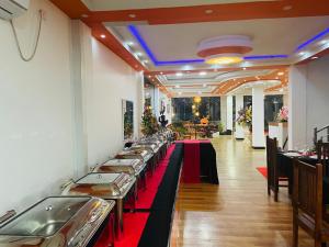 a row of tables in a restaurant with red table runners at Wilroma Hotel&Resort in Anuradhapura