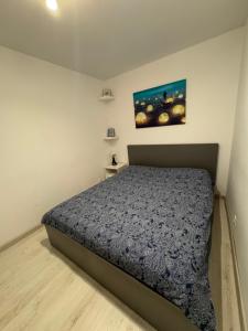 a bedroom with a bed and a painting on the wall at Apartment Pitesti in Piteşti