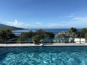 a swimming pool with a view of the ocean at Villa 4 étoiles Le Roc de Malendure in Bouillante
