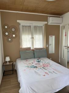 a bedroom with a large white bed with flowers on it at Maison letiluca in Hésingue